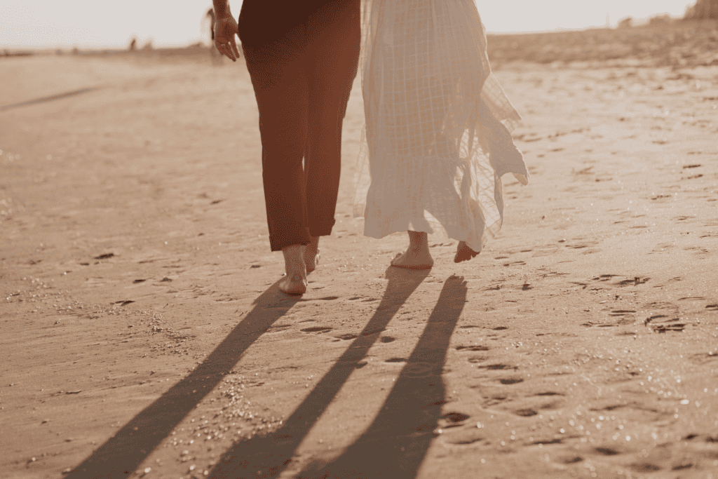 A couple walking on the beach, symbolizing the journey of navigating relationship anxiety together, with the peaceful shoreline in the background.