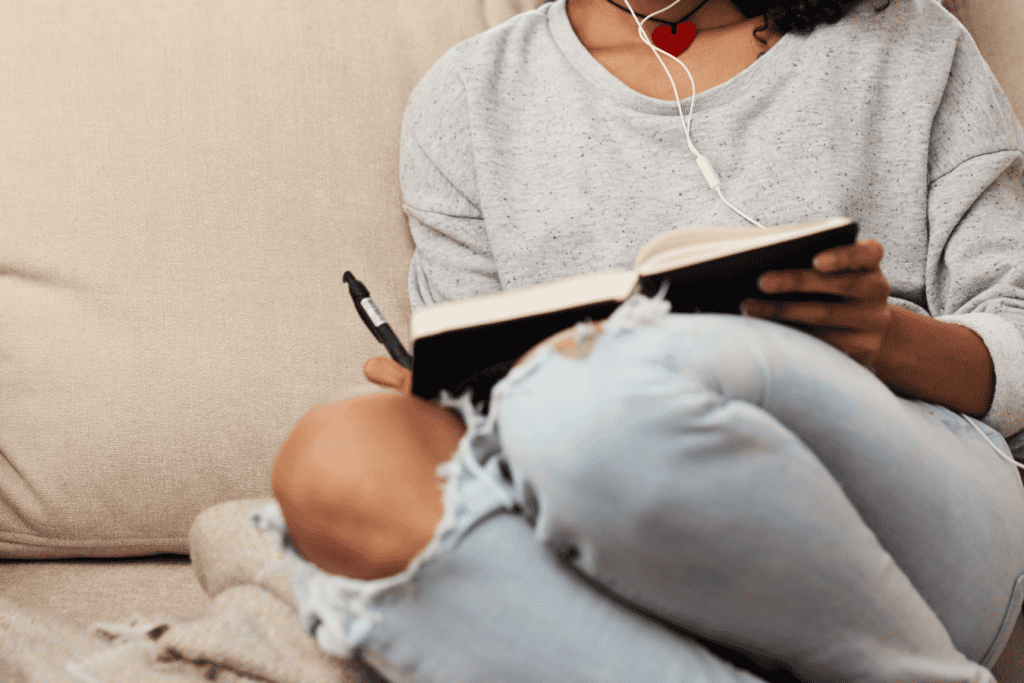 A young woman journaling her thoughts, reflecting on breaking free from people-pleaser habits and focusing on setting healthy boundaries.