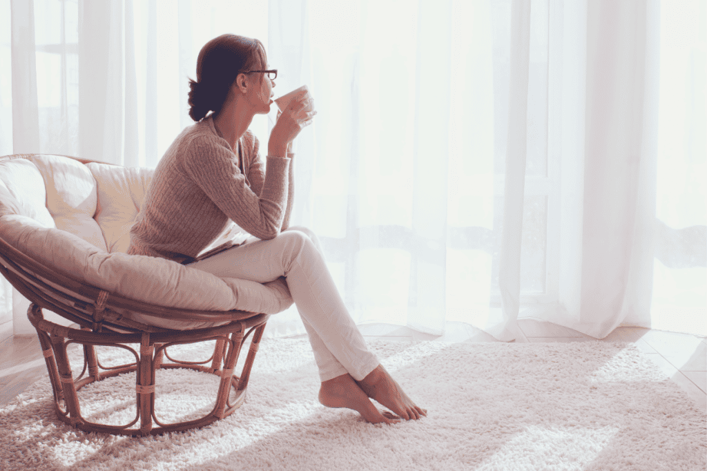 Woman sipping coffee in cozy chair, wondering 'Do I need therapy?'