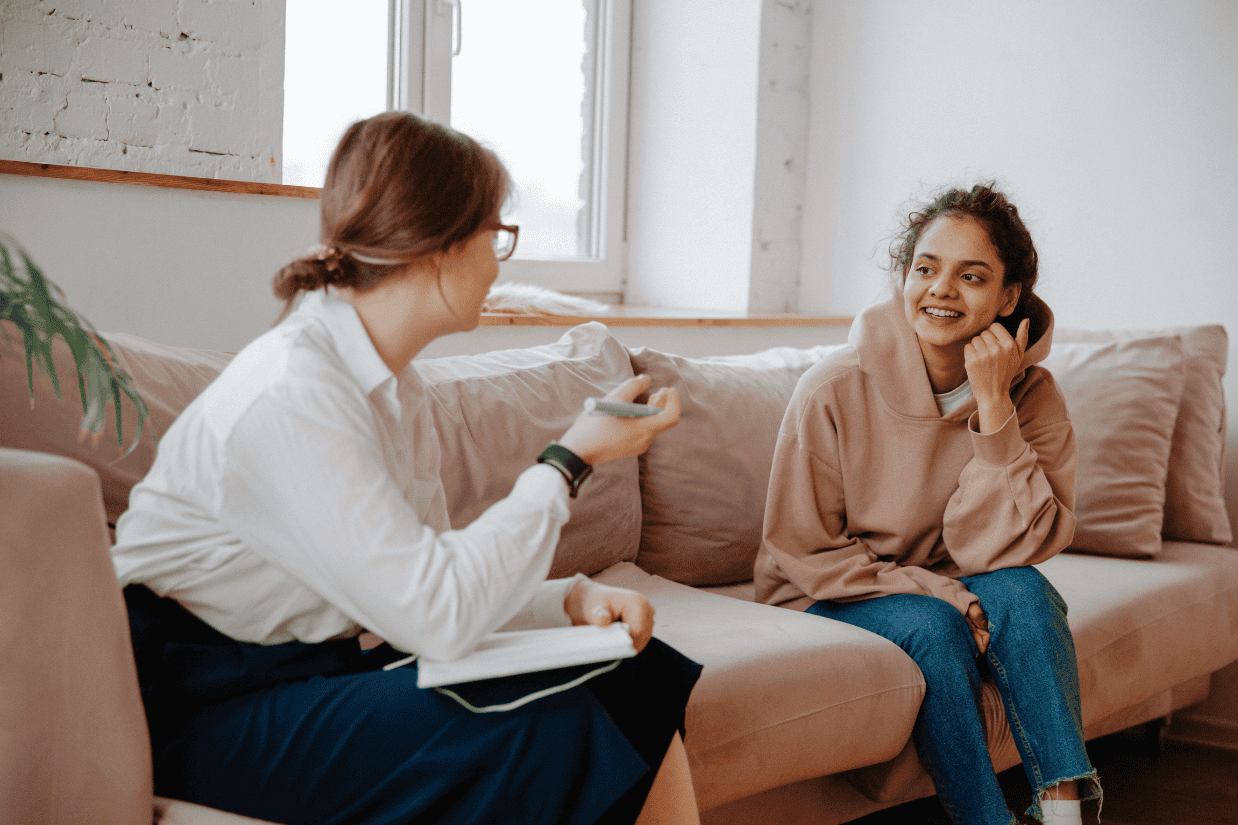 Therapist and young adult client on a couch, creating a supportive space to explore what to say in therapy.