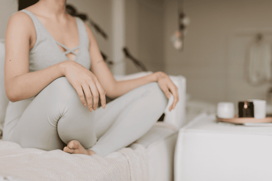 A woman sitting calmly in a yoga pose, practicing mindfulness to manage comfort zone anxiety and embrace discomfort for personal growth.