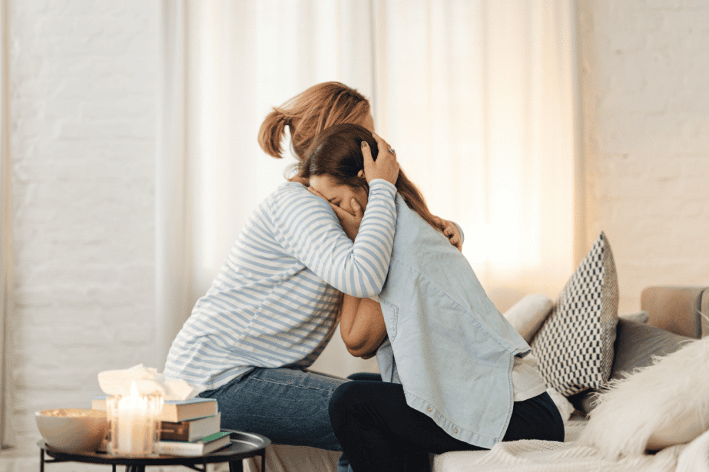 Two people, with one providing support to the other, highlighting the power of asking for help.