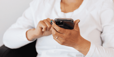 Woman scrolling on her phone alone, caught in a quiet moment of social media comparison.