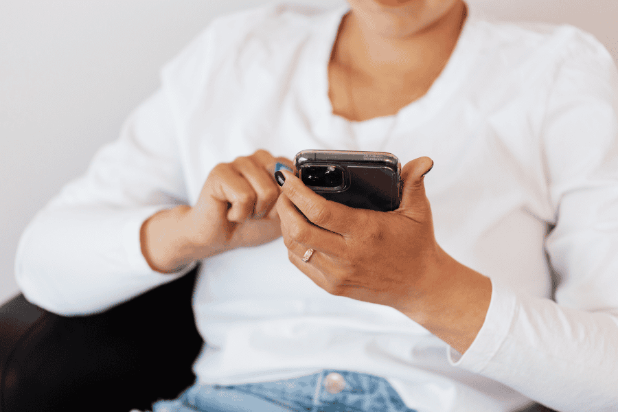 Woman scrolling on her phone alone, caught in a quiet moment of social media comparison.
