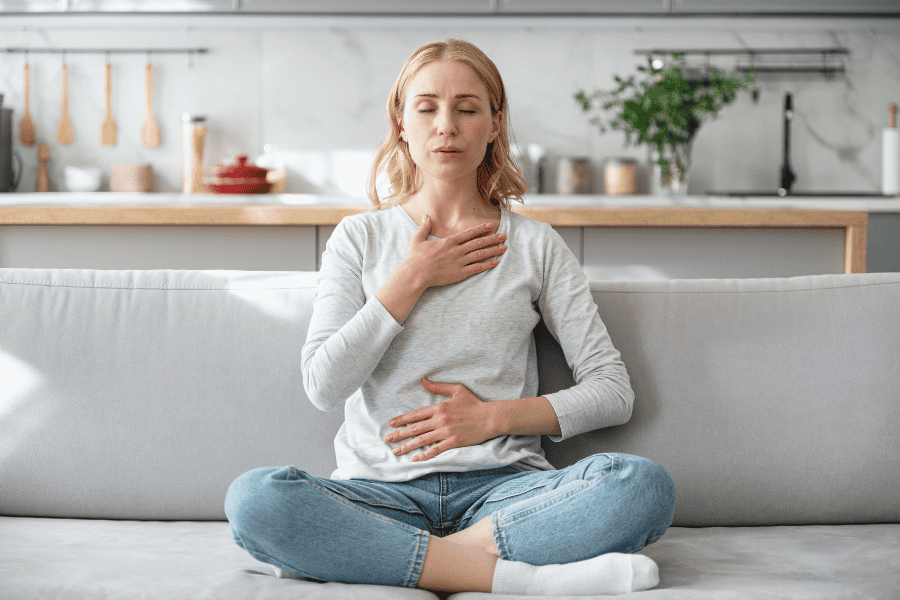 Woman using deep breathing technique to stop a panic attack at home.