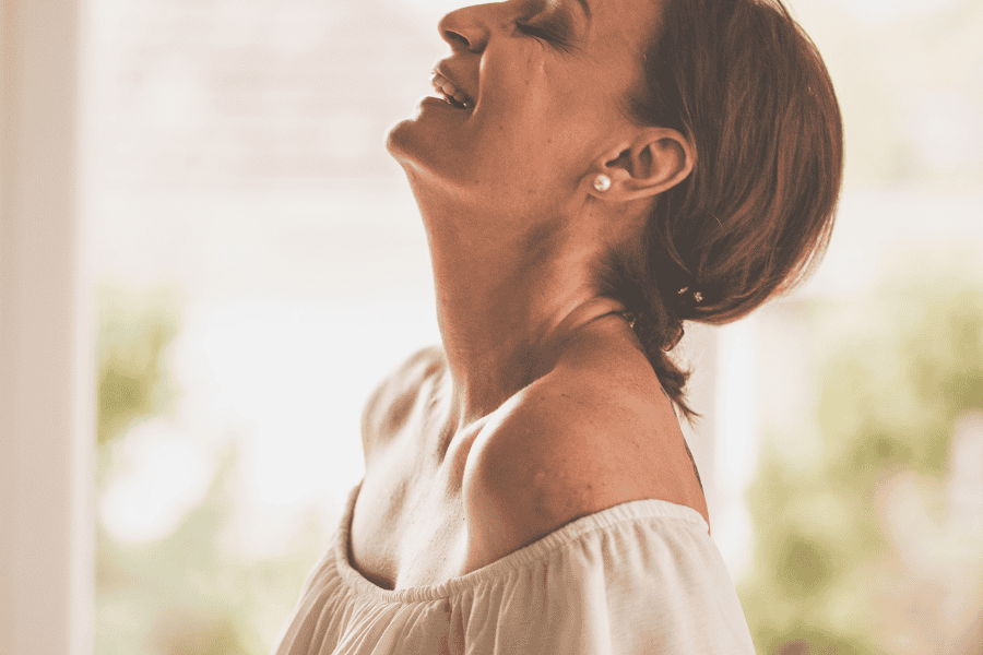 Confident woman smiling and enjoying the moment—capturing what it looks like to explore how to feel good enough in everyday life.