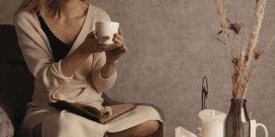 Cozy moment of reflection with candles, coffee, and journaling—symbolizing rest, awareness, and reconnecting with yourself in daily life.